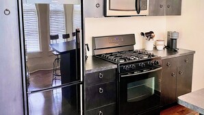 Une cuisine moderne équipée d’un four encastré, d’un four à micro-ondes et d’une cuisinière à gaz.