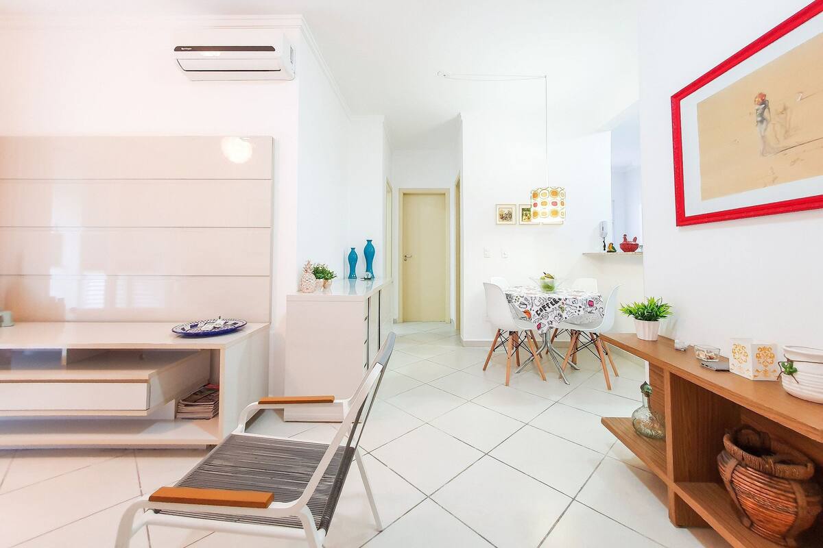 Un salon moderne comprenant un canapé, une table à manger avec des chaises, une table basse et un téléviseur.