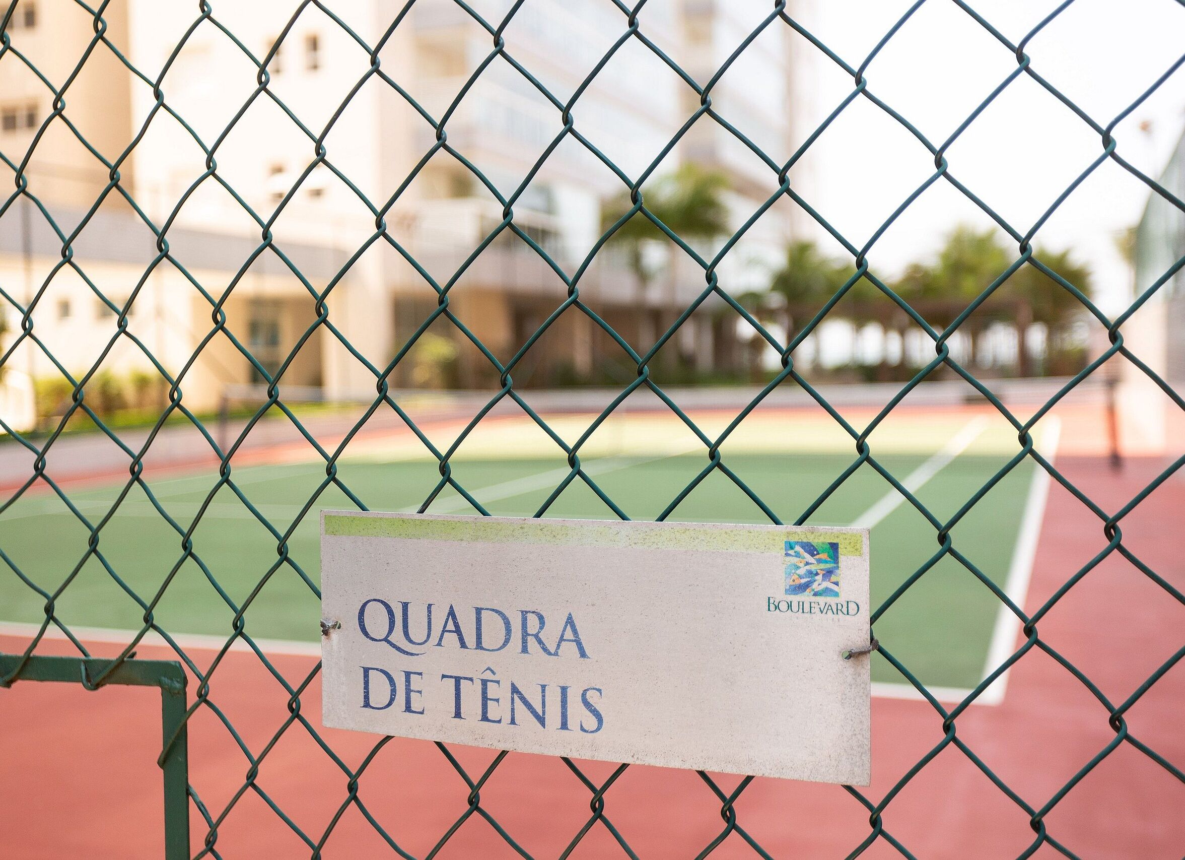 Cancha de tennis amb un cartell que diu "QUADRA DE TENIS" i "Boulevard".