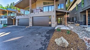 Una moderna casa a due piani con garage, portico coperto e vialetto curato.
