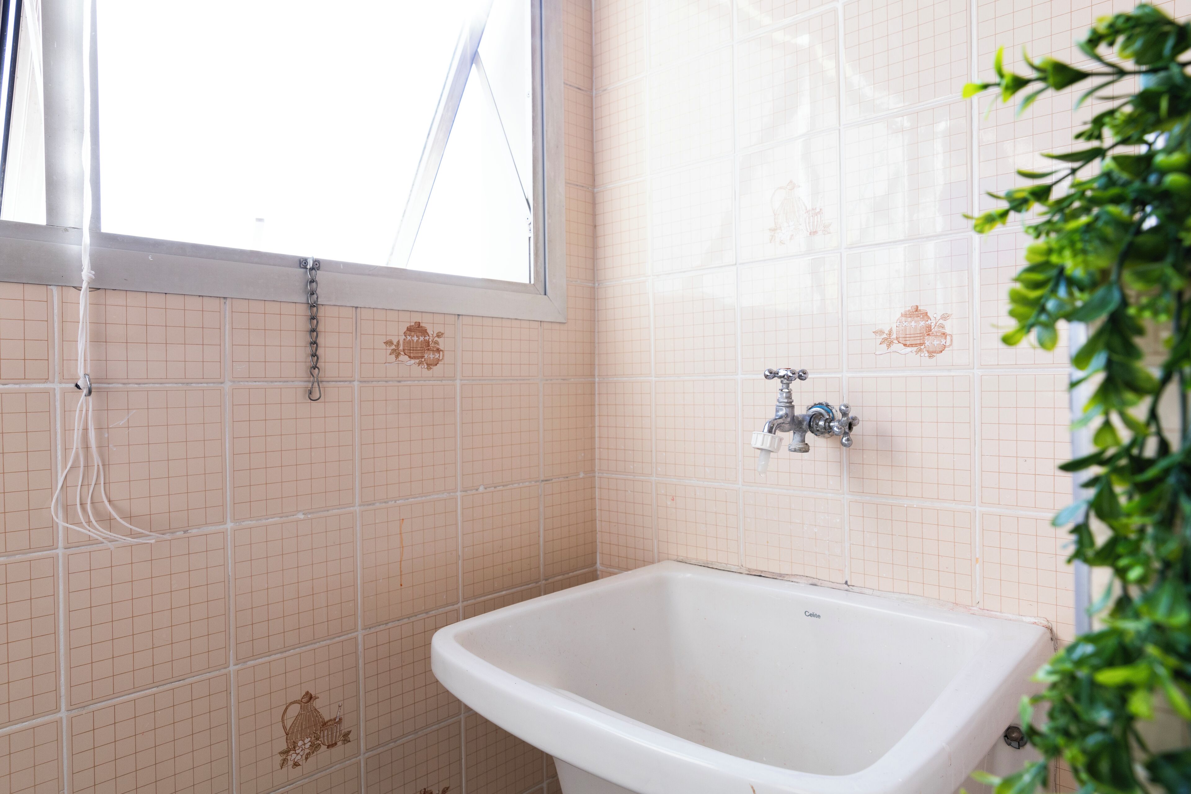 Un baño con bañera, ventana y paredes de azulejos.