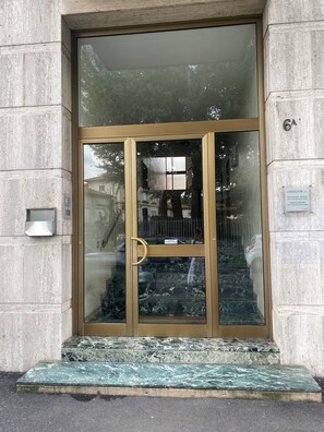 A building entrance with a glass door, a metal handrail, and a marble step. - LILIENBLUM CHIC - ChicLife Apt. - Design apartment Borgo Santa Caterina (Bergamo)