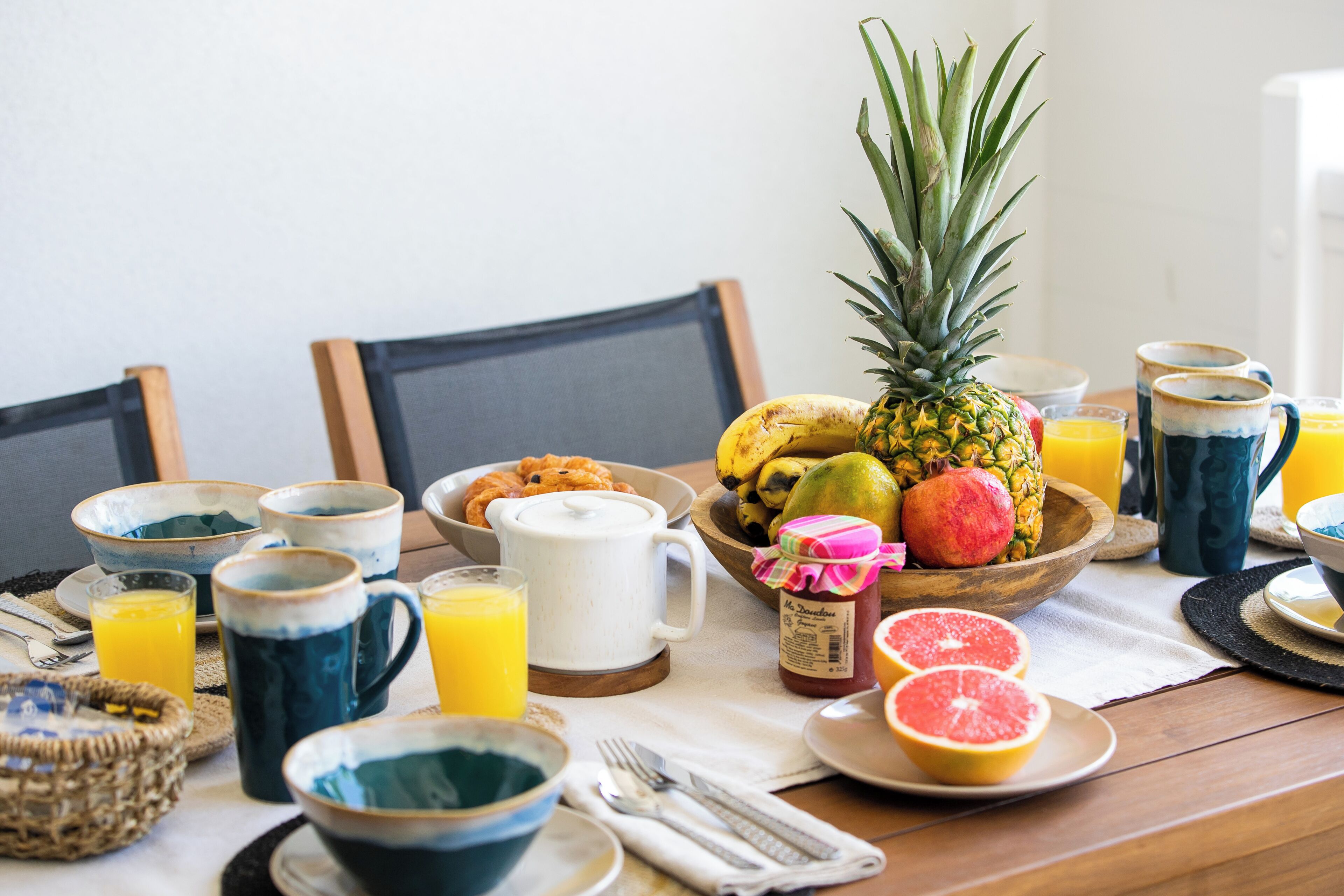 A breakfast table with various fruits, beverages, and breakfast items.