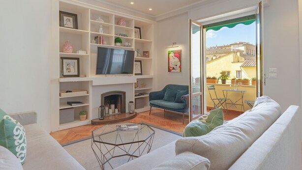 A living room with a fireplace, a television, and a sofa. - Steps to Ponte Vecchio.3BR/3BA+terrace w view of Pitti Palace (Firenze)