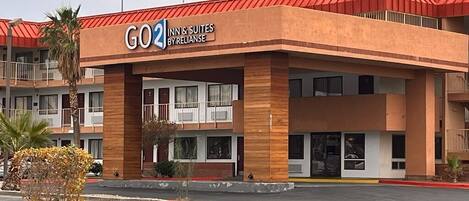 Un hôtel avec un toit rouge et une enseigne sur laquelle on peut lire : « GO2 INN & SUITES BYRELIANCE ».