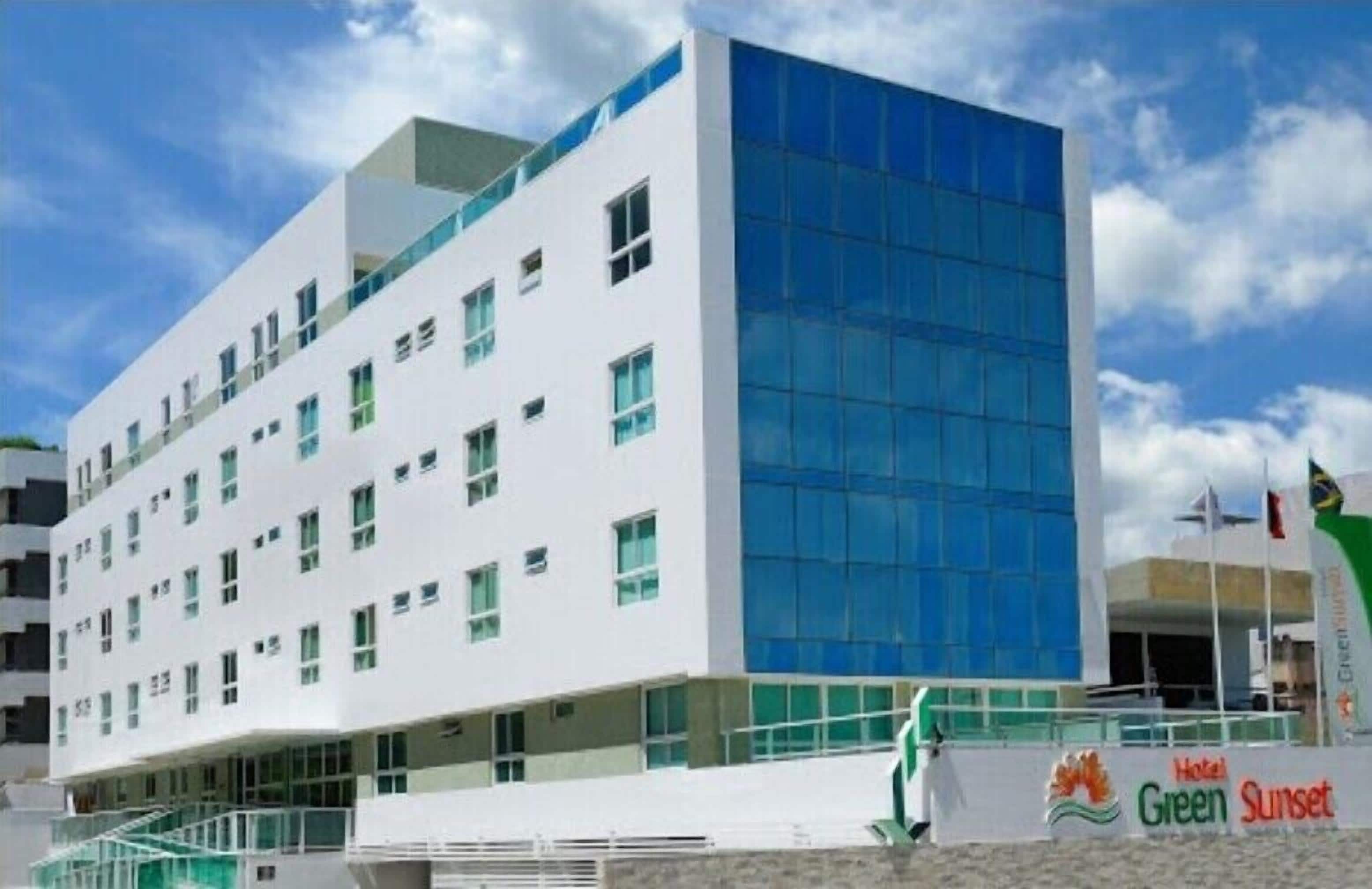Um hotel moderno com fachada branca e grandes janelas de vidro.