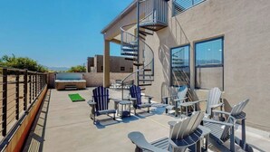 An outdoor patio with Adirondack chairs, a spiral staircase, and a view of the mountains. - Balloon Fiesta: Rooftop Deck, Hot Tub, Sunsets (Albuquerque)