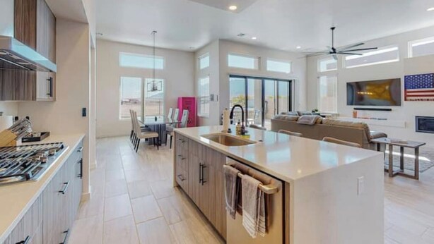 A spacious kitchen with a large island, modern appliances, and a dining area with a sofa and table. - Balloon Fiesta: Rooftop Deck, Hot Tub, Sunsets (Albuquerque)