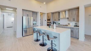 A modern kitchen with a central island, stainless steel appliances, and light wood cabinetry. - Balloon Fiesta: Rooftop Deck, Hot Tub, Sunsets (Albuquerque)