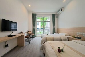 A hotel room with a TV, desk, two beds, a balcony with a view, and an air conditioning unit. - Huguang Holiday Hotel (Guangzhou)