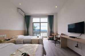 A hotel room with two beds, a TV, a desk, and a balcony with a view. - Huguang Holiday Hotel (Guangzhou)