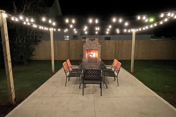 Stone fireplace on the patio featuring a pizza oven & a large dining space