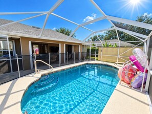 A swimming pool with a covered deck area, a pool ladder, and inflatable pool toys. - 🌴🍹3 Palms Oasis! Heated Saltwater Pool, Poolside TV, Near Beaches, Wi-Fi! (Sebastian)