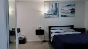 A bedroom with a bed, bedside tables, a nightstand, and abstract wall art. - Comfortable 1 bdrm with a office Nook (Las Vegas)