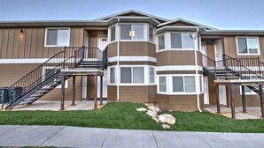 A multi-story residential building with a central courtyard, featuring a staircase on each side leading to the upper floors. - Condo - #310 | 2 Bed, 2 Bath (Garden City)