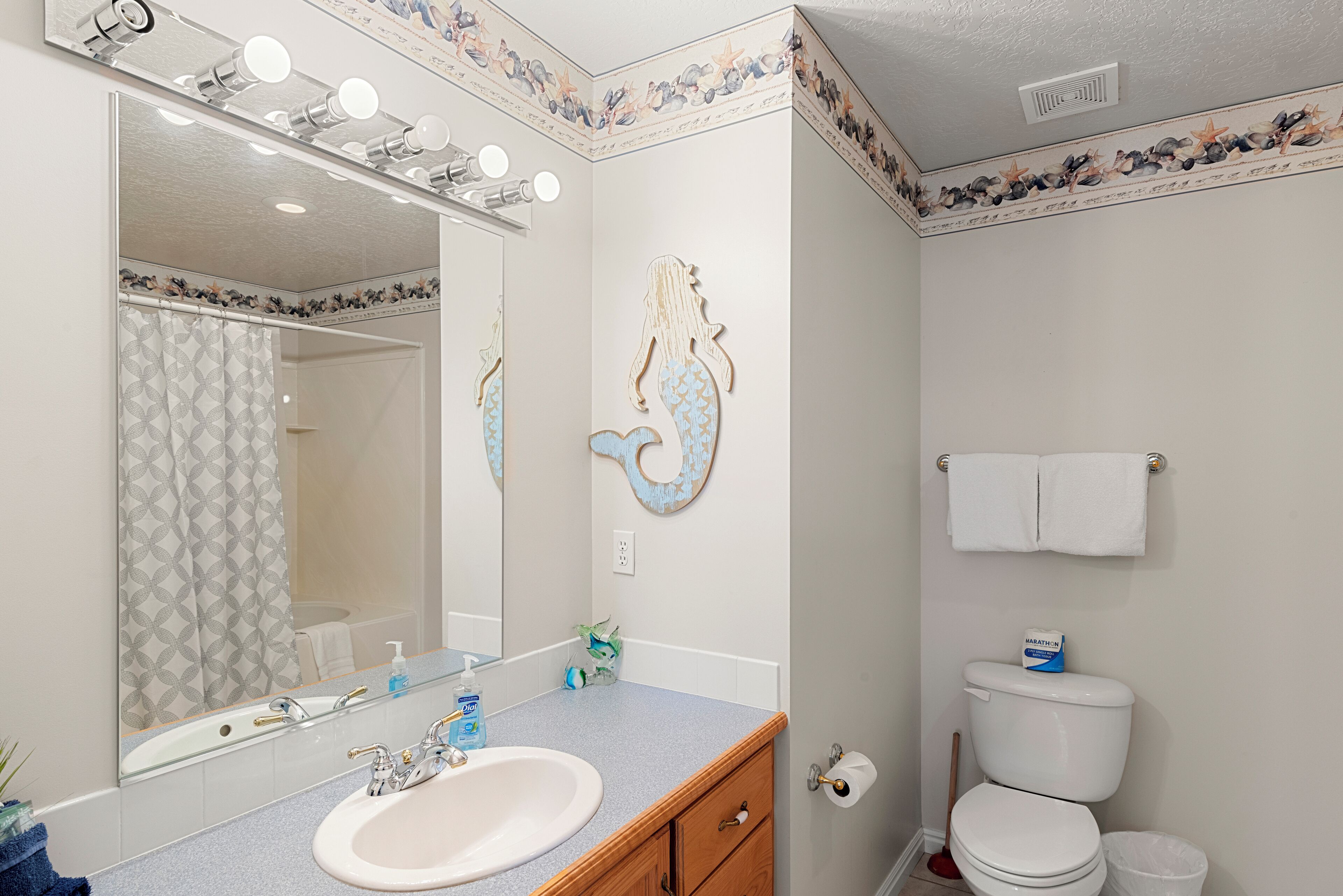A bathroom with a sink, mirror, and toilet.
