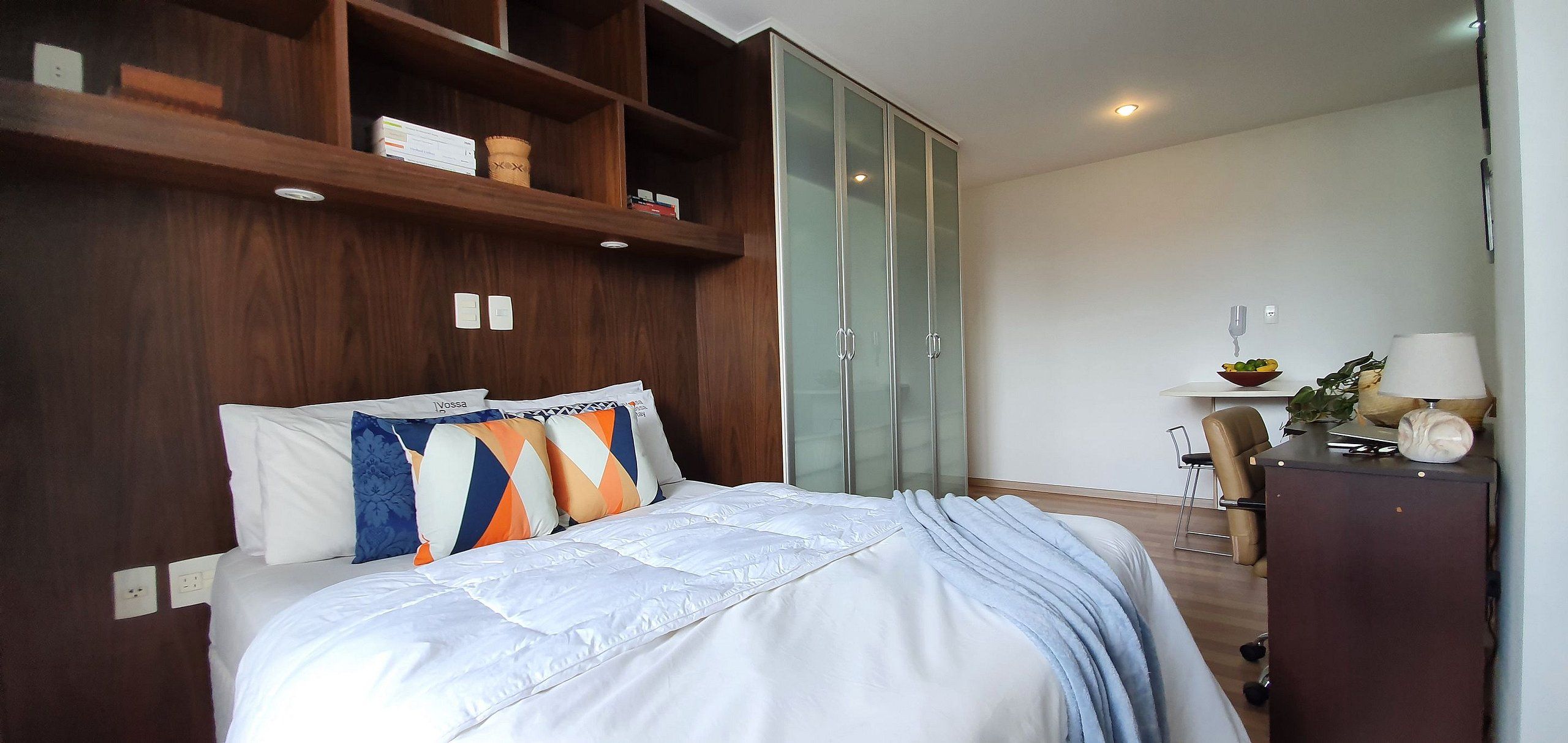 Une chambre à coucher avec un lit, une armoire, un bureau et une chaise.