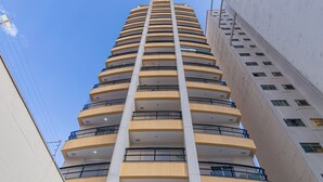 A multi-story building with a central core, balconies, and a clear sky. - Vossa Bossa Bela Cintra Home (São Paulo)