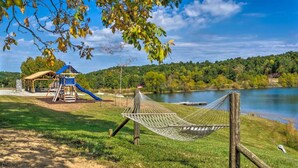 Eine Hängematte, ein Spielplatz und ein See.