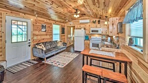Ein Blockhaus-Interieur mit Wohnzimmer, Küche und Essbereich.