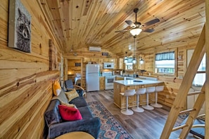 L’intérieur d’une cabane en rondins comprend un espace de vie, une cuisine et un coin bar.