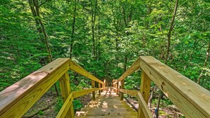 Una escalera de madera que se adentra en un bosque.