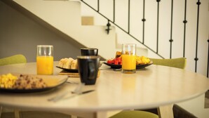A breakfast table with plates of food, glasses of orange juice, and a coffee mug. - Condo Pacifico Quepos, 5 minutes from National Park Manuel Antonio (Quepos)