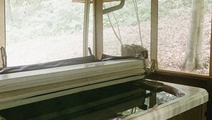 Una cabaña de madera con un jacuzzi y un banco.