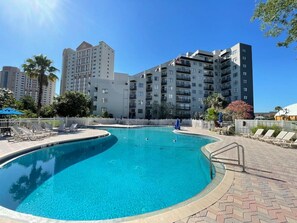 Relax by the resort's pool surrounded by comfortable lounge chairs and shaded areas.