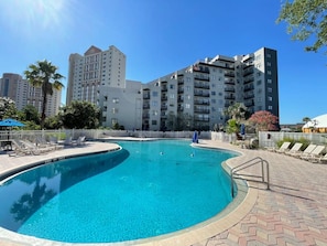 Relax by the resort's pool surrounded by comfortable lounge chairs and shaded areas.