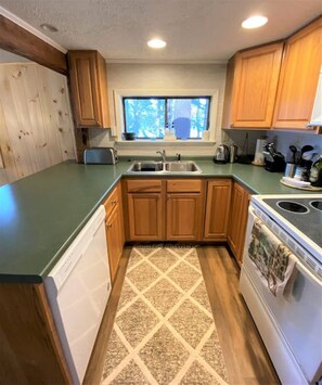 Kitchen with sink, window, and cabinetry.