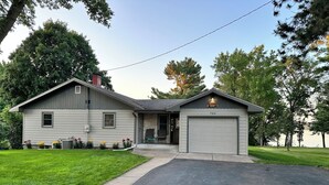 Ein zweigeschossiges Haus mit Garage, überdachter Veranda und gepflegtem Rasen.