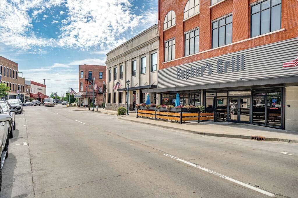 Straatbeeld met een restaurant genaamd "Coppertone's Grill", met terras en een gebouw van baksteen.