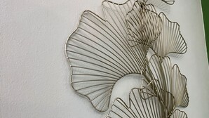 Una escultura de hoja metálica colgada en la pared.