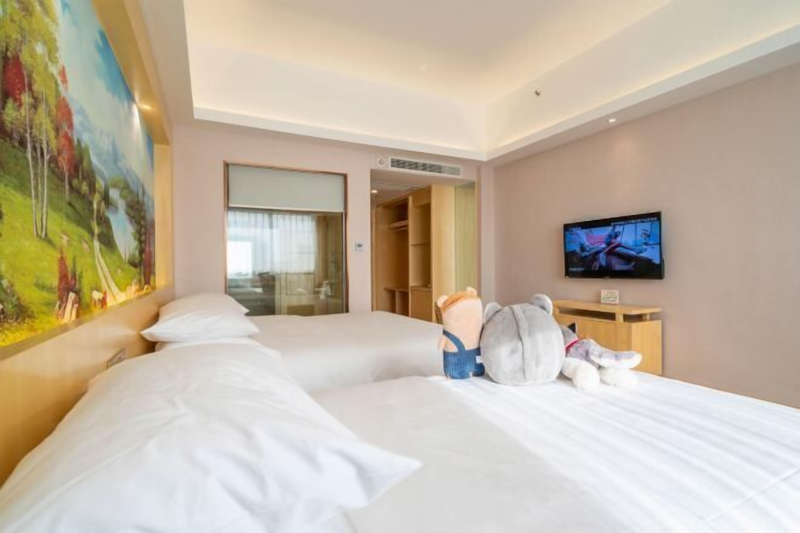 A hotel room with a large bed, a television, a painting, and a closet.