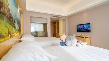 A hotel room with a large bed, a television, a painting, and a closet.