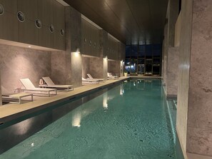 Relax by the rectangular pool surrounded by lounge chairs and tables.