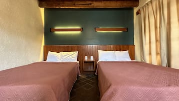 Quarto com duas camas, cabeceiras de madeira e parede verde.