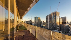 A balcony with a view of a cityscape, including high-rise buildings and construction cranes. - Spacious CBD Penthouse w Parking Pool and Gym (West Melbourne)