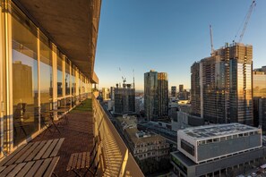 Un immeuble de grande hauteur doté d’une terrasse offrant une vue sur le paysage urbain.