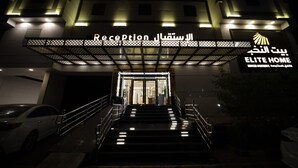 A hotel entrance with a reception area, a staircase, and a parking lot. - PRIMOTEL Elite As Salamah (Jeddah)