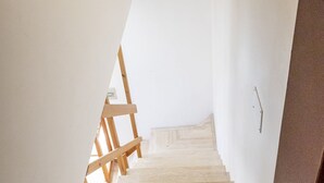 Eine Treppe mit Holzhandläufen, die zu einer Empore führt.
