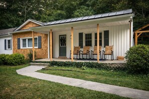 A single-story house with a covered porch, a front door, and a small front yard.