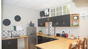 A modern kitchen with a central island, built-in appliances, and a dining area with wooden chairs.