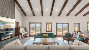 Un salón amplio con chimenea, ventanas grandes y vistas al exterior.