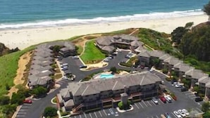 Un hôtel situé sur la côte, composé de plusieurs bâtiments, doté d’un parking et offrant une vue sur la plage.