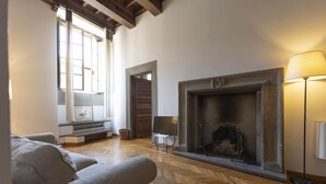 Ein geräumiges Wohnzimmer mit Kamin, Holzböden und einer Couch.