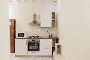 A compact kitchen with a microwave, stove, oven, and a built-in sink. - San Gallo Inn Canaiolo (Firenze)