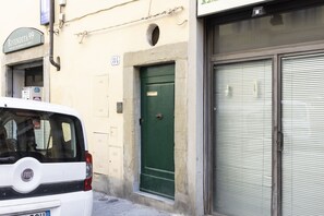 A white car parked in front of a building with a green door and a sign above it. - San Gallo Inn Canaiolo (Firenze)