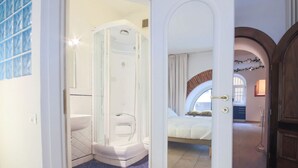 A modern bathroom with a glass-enclosed shower, a white toilet, and a blue-tiled floor. - Duomo Deluxe Apartment (Firenze)